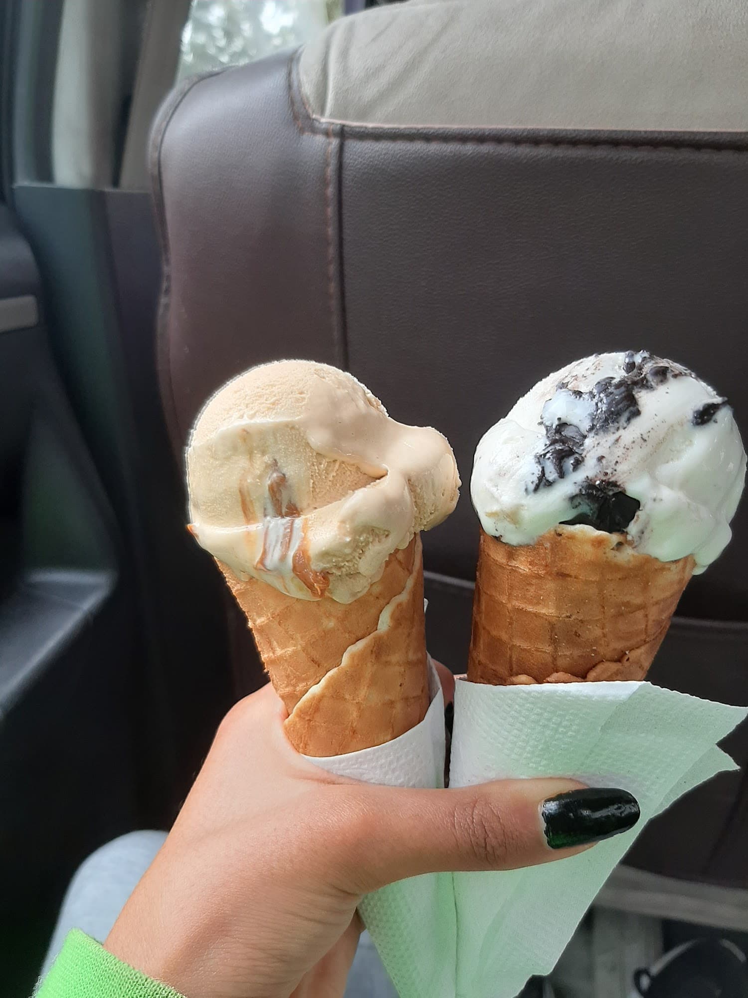 Handheld gelato cones with different flavors, one featuring cookies and cream
