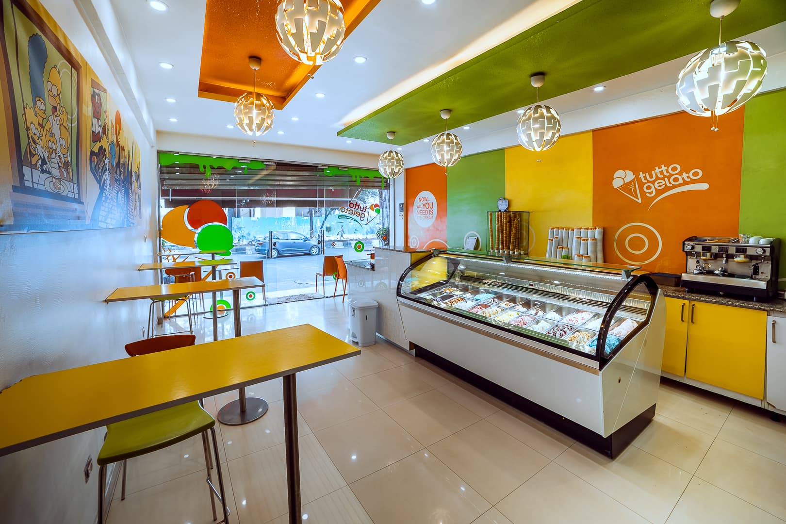 Wide shot of the interior of Tutto Gelato shop with seating and menu board