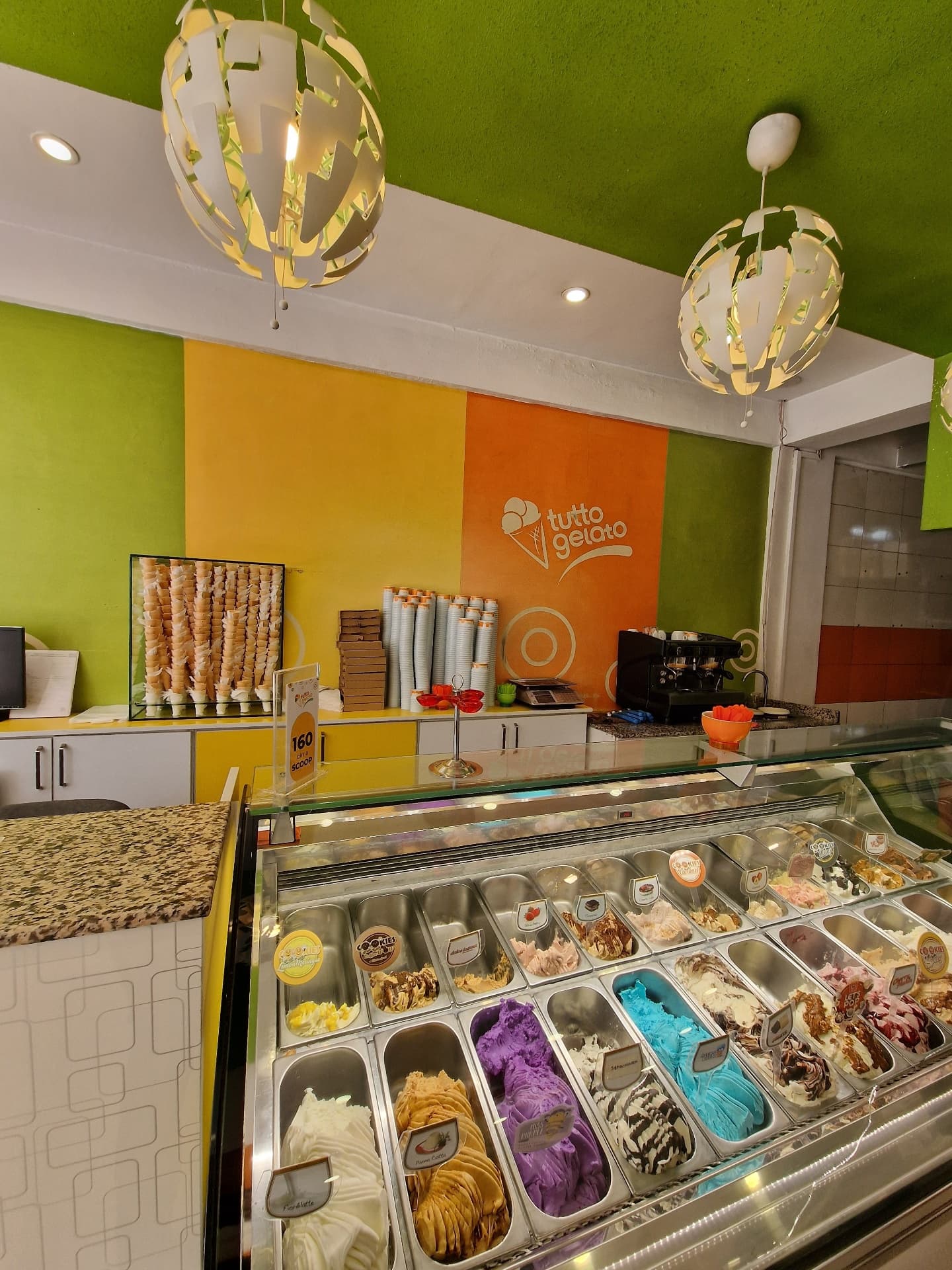 Tutto Gelato store interior display case featuring various colorful gelato flavors
